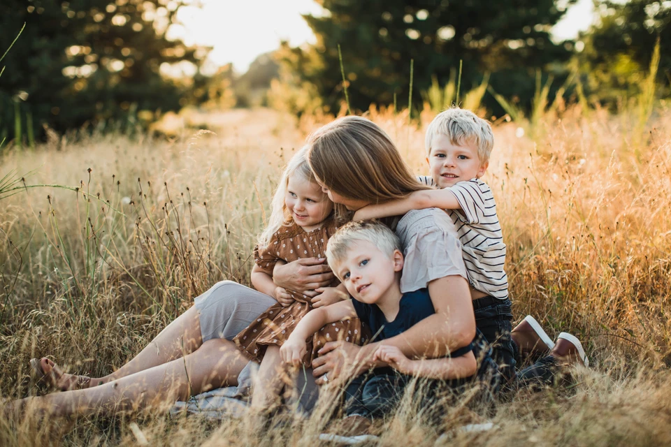 Mother and 3 children snuggle in a lifestyle family pose.