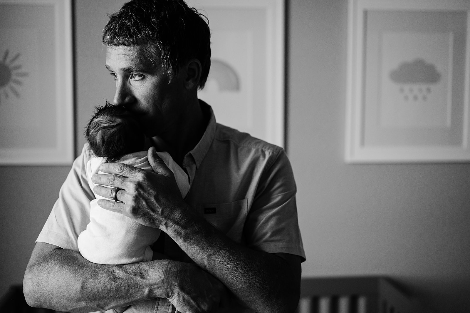 Photo of a father holding his newborn at home by Liz Putnam.