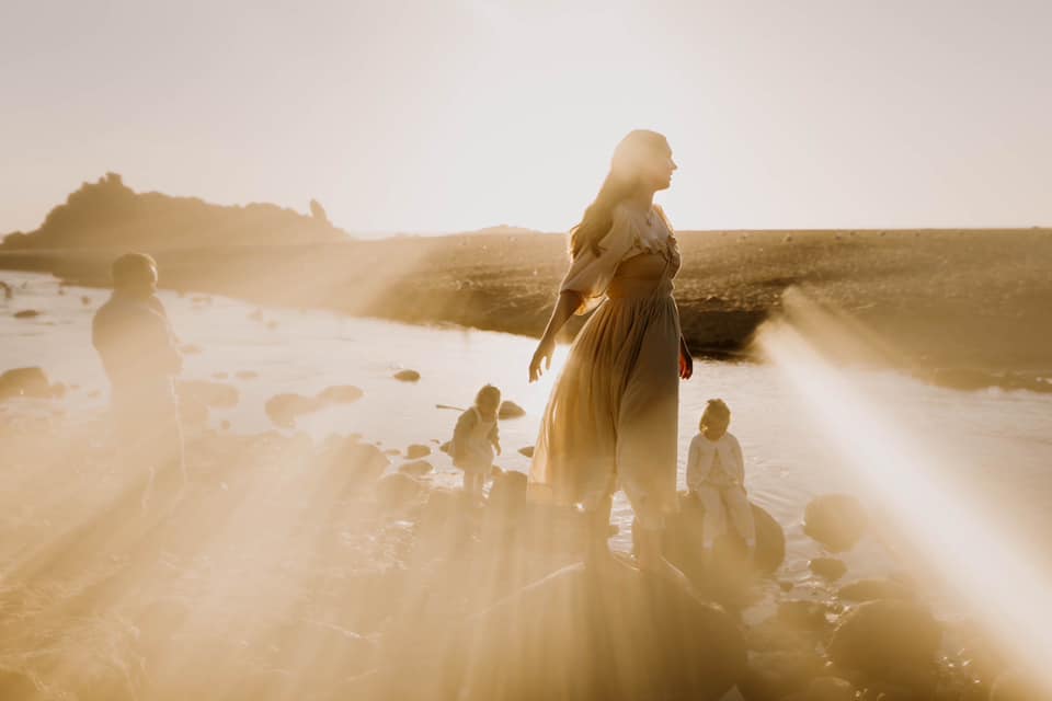 Photo of a family playing by a river at sunset by becca lueck photography