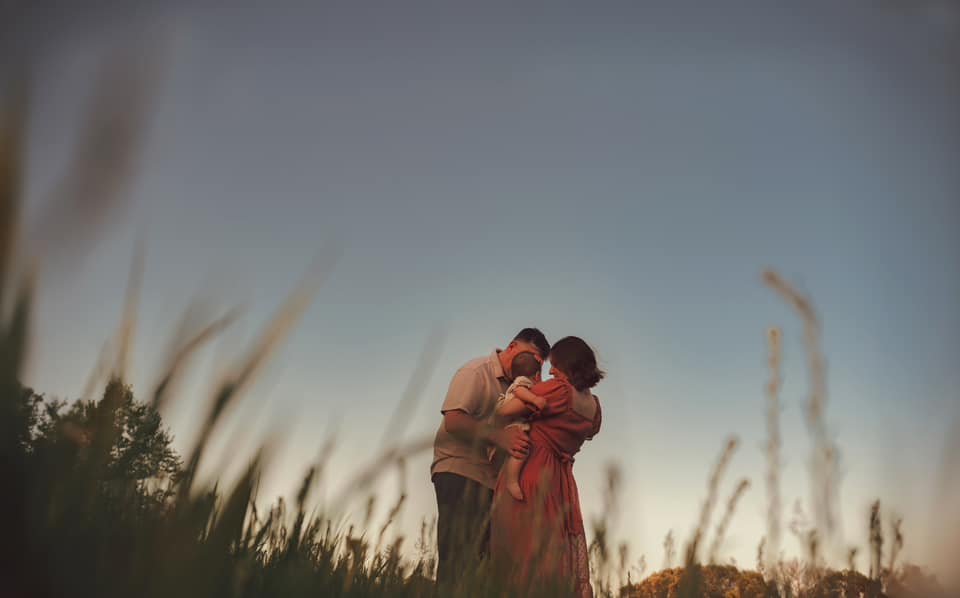 Photo of a family in a field at sunset by Shannon O'Malley photography