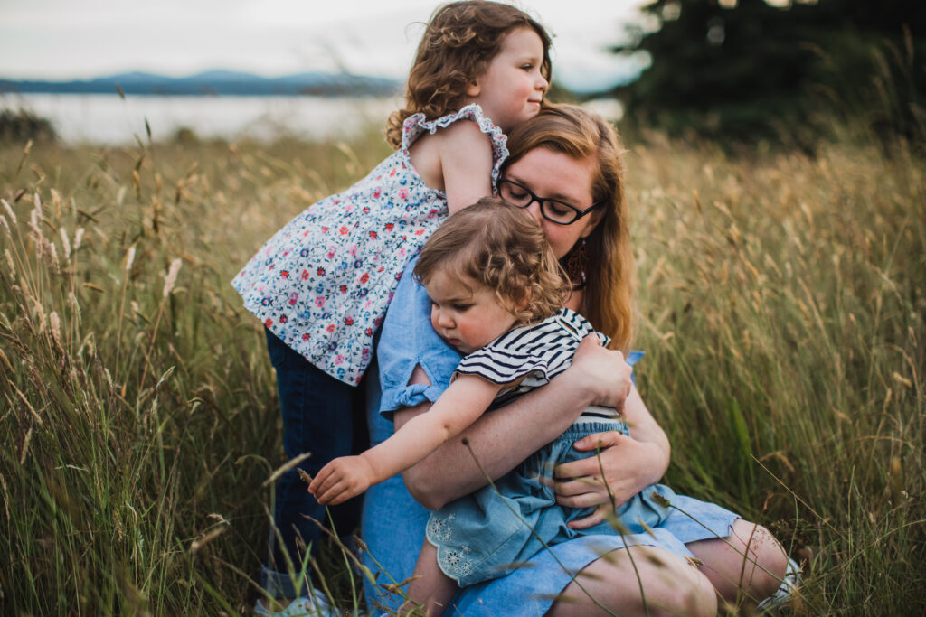 Mother and her two children embrace each other in a lifestyle photography pose.