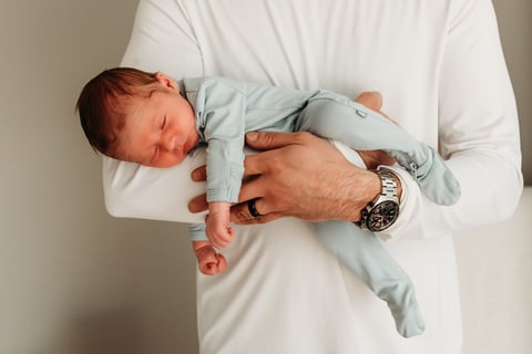 dad holds newborn baby.