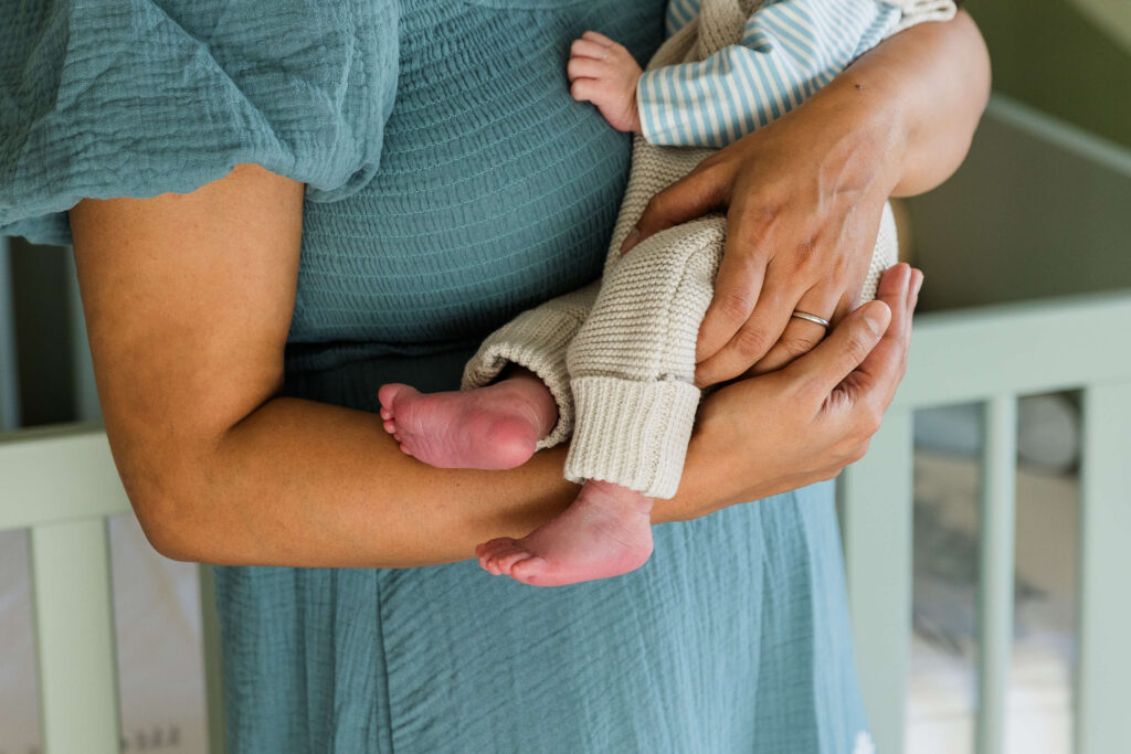 mother holds baby in her arms in the nursery.