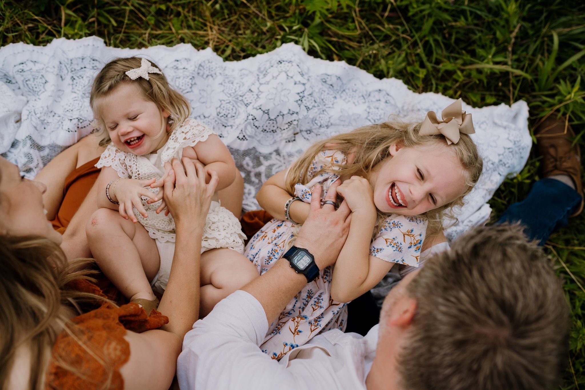 Finalist image from the July 2025 Photography Contest candid moment of children laughing in a sunlit field.