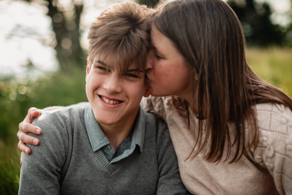 A lifestyle family photography image showing relaxed family posing with mom and teenage son.