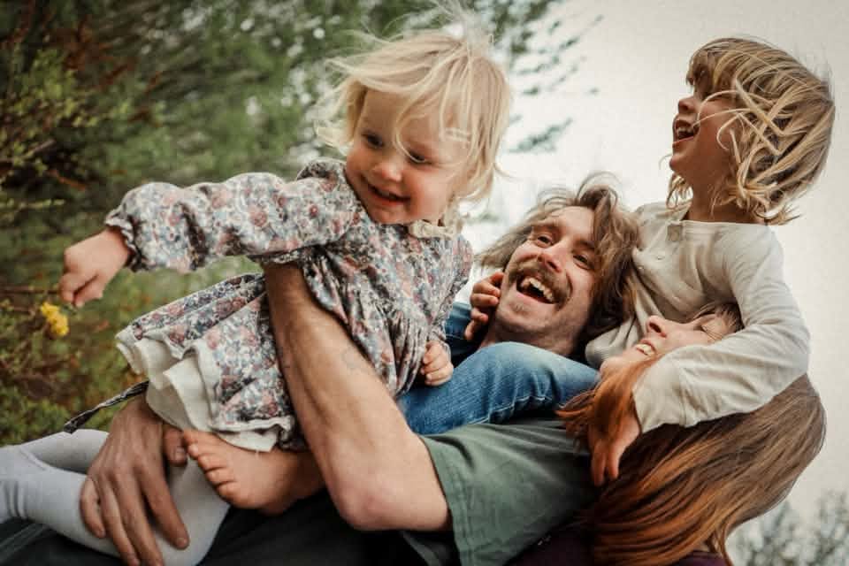 Siblings and Dad smiling and laughing together featured in the Elena S Blair Education Facebook cover contest.